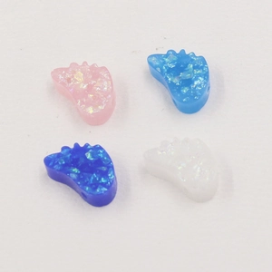 Detail of synthetic resin opal beads in foot shape with glitter for DIY jewelry