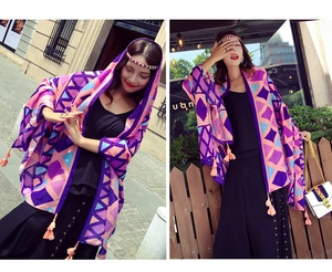 Detail view of ethnic geometric pattern shawl with pink tassel fringe decoration