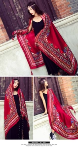 Close-up of red ethnic embroidered shawl with tassels and detailed bohemian patterns