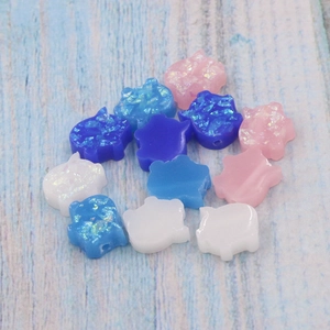 Close-up of 11mm pig-shaped synthetic opal beads in pink, blue and white colors