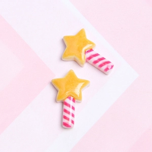 Detail of yellow star lollipop charms with pink and white striped handles for DIY