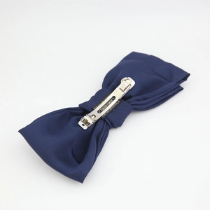 Detail of a handmade dark blue satin double-layer bow hair clip with a metal spring clasp