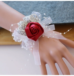 Détail du corsage de poignet rose en satin rouge avec rubans en mesh et perles