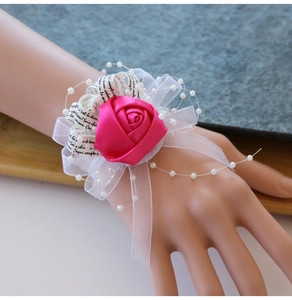 Détail du corsage de poignet rose en satin avec perles blanches et rubans en organza