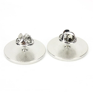 Detail of silver zinc alloy brooch back with butterfly clutch and textured base