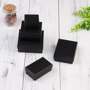 Linen texture black jewelry gift boxes in various sizes on a white wood background