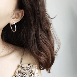 Polished 925 sterling silver Mobius hoop earrings worn by a model for a stylish look