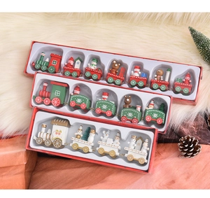 Detailed view of hand-painted wooden Christmas train sets in red white and green colors