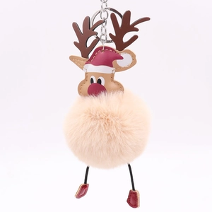 Close-up of Christmas reindeer keychain with plush pompom and festive red hat detail