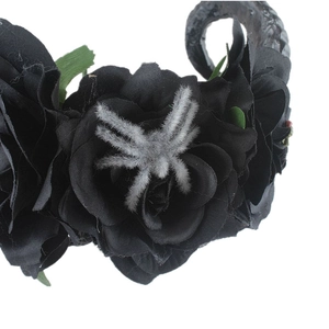 Detail of gothic floral headband with black roses, a plush spider, and dark horns