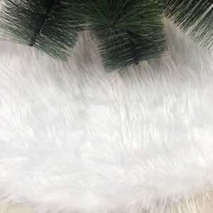 Plush white faux fur Christmas tree skirt with long shaggy texture for festive base decor