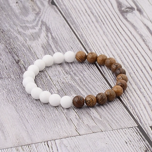 Detail of wooden grain beads and white resin beads on a minimalist elastic bracelet