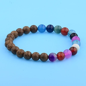Macro view of multi-color beaded bracelet with natural wood grains and elastic cord