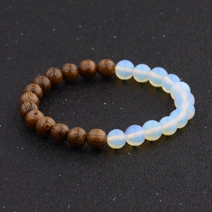 Macro detail of wooden and milky white beads on a beaded stretch bracelet