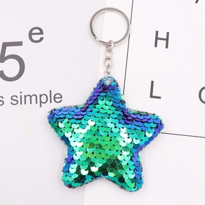 Close-up of star-shaped keychain with teal gradient sequins and silver metal ring