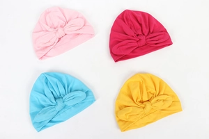 Detail view showing pink, rose, sky blue, and yellow bow knot baby turbans in soft knit fabric