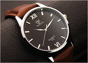 Close-up of Yazole 318 quartz watch with black dial, roman numerals and brown leather strap