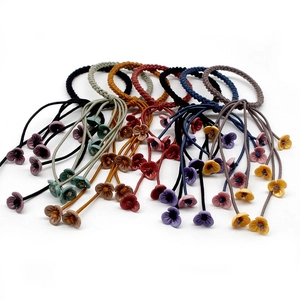 Detailed view of elastic hair ties with colorful 3D flower pendants on white background
