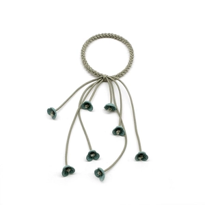 Detail of forest style hair tie with woven green elastic ring and hanging flower petals