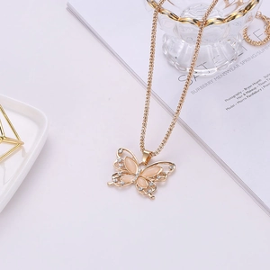 Elegante collar de mariposa dorado con piedras ojo de gato rosa y cristales