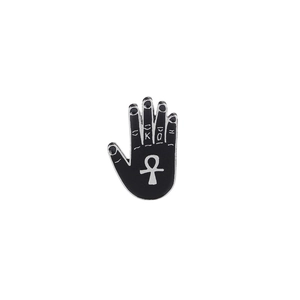 Detail of a punk enamel palm brooch with black plating and engraved Ankh symbol