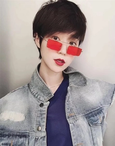 Close-up of red rectangular sunglasses with thin metal frames worn with a denim jacket