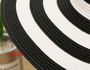 Detailed close-up of woven sun hat brim featuring classic black and white stripes