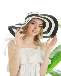 Close-up of black and white striped straw sun hat with premium woven texture details