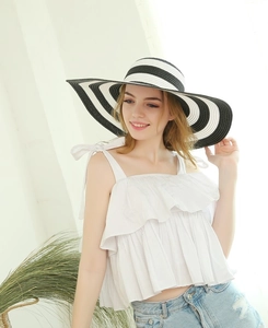 Close-up of a wide brim straw hat with classic black and white stripes for sun protection