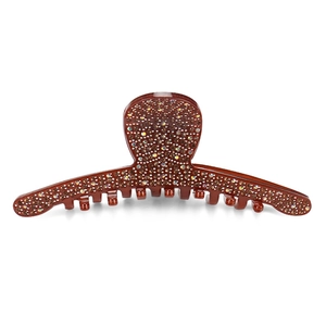 Close-up of brown hair claw clip with sparkling amber rhinestones on white background
