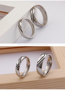 Detail of couple rings set in polished titanium steel with black streamlined engraving