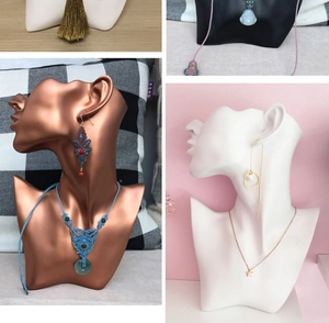 Detail shot of resin jewelry stand showing necklaces and earrings on portrait bust