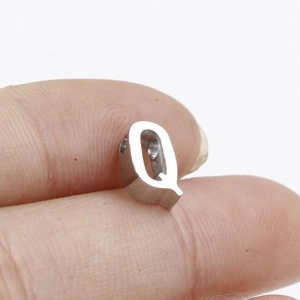 Close-up of polished stainless steel letter Q pendant connector for DIY jewelry making