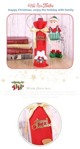 Detail of red flannel Santa wine bottle cover with gold ribbon for holiday table decor