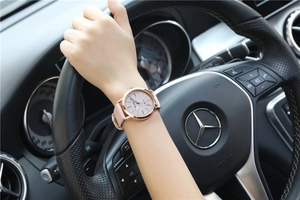 Nahaufnahme einer Damen-Quarzuhr mit rosa Glitzer-Zifferblatt und Roségold-Gehäuse am Arm