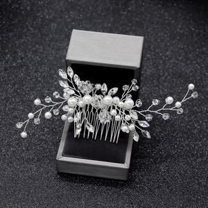 Close-up of bridal hair comb with white pearls and sparkling marquise crystals on silver wire