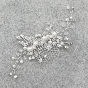 Detailed view of bridal hair comb with white pearls and clear crystals on silver wire