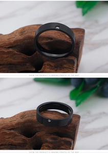 Detail of matte black titanium steel ring with horizontal grooves and a single square zircon