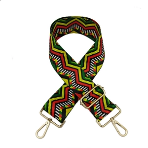 Close-up of wide woven shoulder strap with colorful geometric waves and gold metal hooks