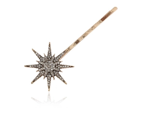 Dettaglio ravvicinato di un fermaglio per capelli a stella dorata con strass bianchi