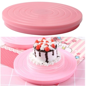 Pink rotating plastic cake turntable showing a strawberry cream cake on a decorated stand