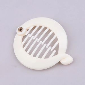 Detailed top view of a cream-colored round banana hair clip with plastic teeth and metal hinge