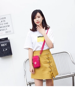 Detailed view of magenta mini crossbody phone bag with three-layer zipper design
