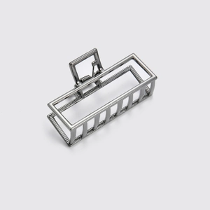 Dettaglio di un fermaglio geometrico in metallo grigio canna di fucile con design rettangolare