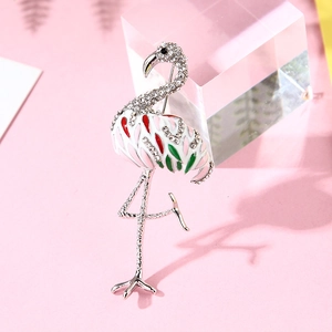 Elegant flamingo brooch with white enamel and sparkling rhinestones on pink background