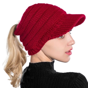 Gros plan sur le bonnet en tricot rouge pour queue de cheval avec texture en laine