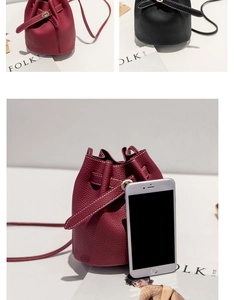 Mini lychee texture bucket bag in red and black compared to a phone for scale