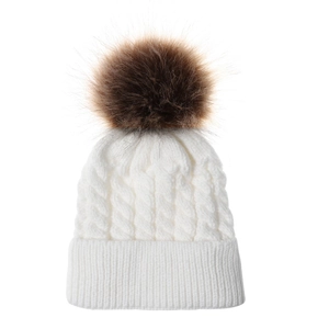 Close-up of white cable knit beanie with fluffy faux fur pompom for winter warmth