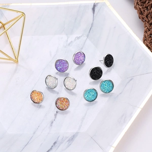 Detailed view of colorful Druzy stud earrings set in a white marble jewelry tray