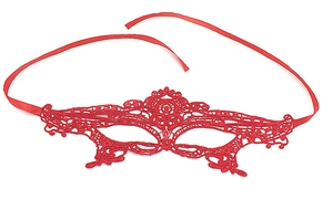 Macro detail of red lace masquerade mask showing intricate floral texture and satin ribbons